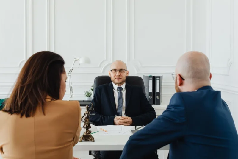 A lawyer reviewing a matter with clients at a desk