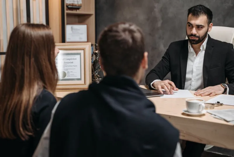 A lawyer reviewing paperwork with clients at a desk