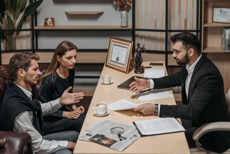 A lawyer explaining documents to two clients